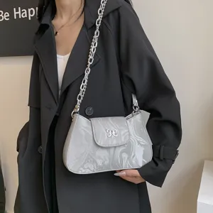Modische silberne Metallic-Achseltasche für Damen mit klobiger Kette und Schleifenschloss.