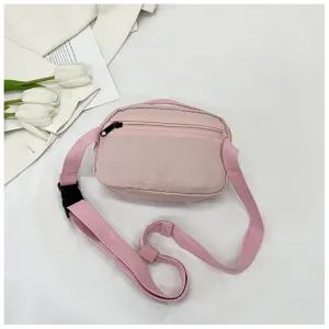 Pink nylon crossbody phone bag, casual small shoulder bag with zipper and adjustable strap.