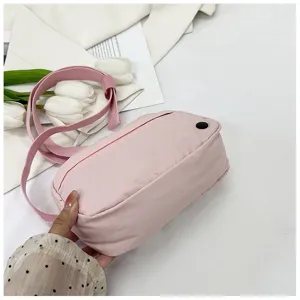 Close-up of pink nylon crossbody bag detail, casual phone purse with adjustable strap.