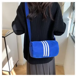 Detailed view of the blue nylon barrel crossbody bag with white stripes, casual daily use.