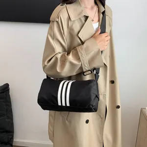 Black nylon crossbody shoulder bag with white stripes, casual large travel pillow bag.