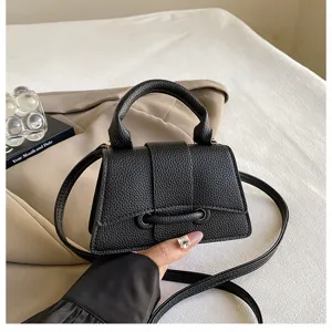 Classic black leather top handle crossbody bag for women, stylish structured shoulder bag.