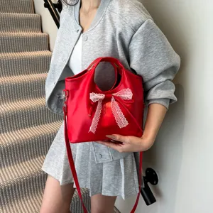 Red PU leather bucket bag for women with elegant white lace bow, versatile shoulder handbag.
