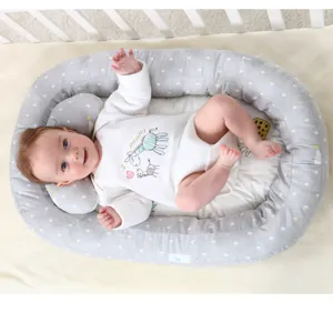 Portable baby nest bed for newborns, breathable bionic crib with comfortable cushion and pillow.