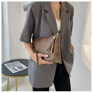 Sac pochette pour femme marron texture avec details de pampilles, ideal pour automne hiver.