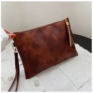 Sac pochette femme marron texture vintage avec frange, sac à main élégant et tendance.