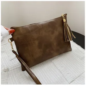 Détail de pochette marron en cuir PU, design texture vintage avec élégant pendentif à franges.