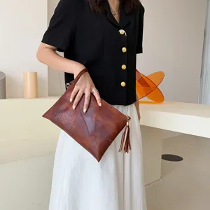 Sac pochette marron texturé rétro pour femme avec gland, sac bandoulière vintage élégant.