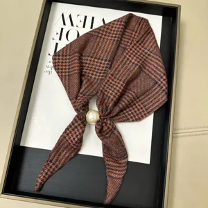 Detail shot of brown houndstooth silk scarf neckerchief with elegant white pearl magnetic buckle.