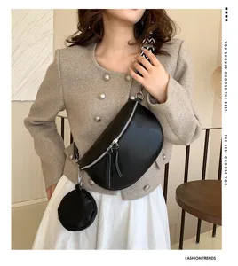 Stylish women's black leather chest bag crossbody saddle bag with small round pouch detail.