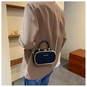 Sac bandoulière ovale chic avec chaîne et poignée torsadée pour femme mode.