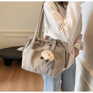 Detailed view of the casual corduroy tote bag with plush pendant, perfect for daily commute.