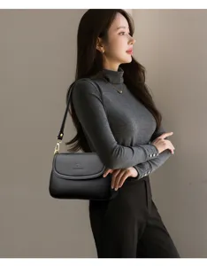 Detailansicht einer eleganten schwarzen Schultertasche aus Leder mit Metallverschluss.