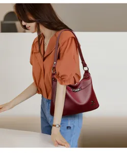 Detailaufnahme einer roten Damen-Lederschultertasche mit Kettenakzent, stilvoll präsentiert.