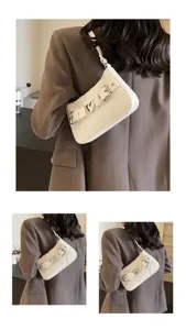 Élégant sac à bandoulière blanc effet croco avec boucle cœur, chic et tendance pour femmes.