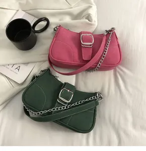Elegante borsa a tracolla in camoscio rosa e verde con catena metallica e fibbia.