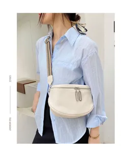 Detail view of genuine leather saddle bag with wide strap and double zippers for women casual.