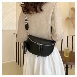 Detailed view of the stylish black leather saddle bag with wide patterned strap and coin purse.