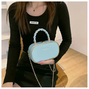 Sac à main rigide bleu clair élégant avec poignée tressée et chaîne dorée chic.