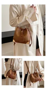 Elegante braune Beuteltasche für Damen im Vintage-Stil mit modischen Metalldetails und Schulterriemen.