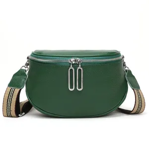 Green leather saddle bag for women, stylish crossbody bag with striped strap and zipper.