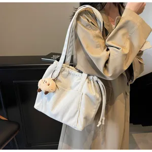 Corduroy shoulder tote bag with drawstring closure and cute plush pendant for daily commute.