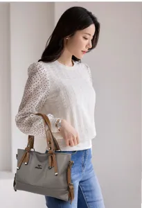 Grey soft leather shoulder handbag detail view, showing brown handles and daily casual style.