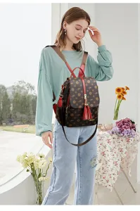 Sac à dos décontracté pour femme avec motif floral, pompon rouge et bretelles confortables.