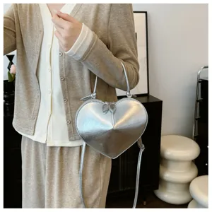 Dettaglio borsa a mano argentata a forma di cuore, borsa a tracolla elegante da donna.