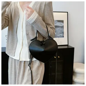 Dettaglio borsa a tracolla nera a forma di cuore, elegante borsa in pelle PU, accessorio moda.