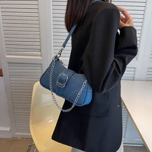Vista dettagliata della borsa a tracolla in denim alla moda con catena metallica e fibbia.