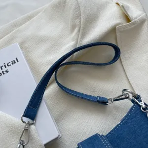 Dettaglio della tracolla della borsa in denim, borsa a spalla da donna casual con metallo.