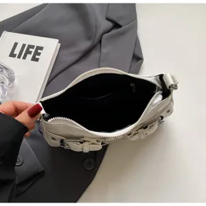 Detail de sac d'epaule blanc texture sous les bras avec boucle en metal et fermeture eclair.