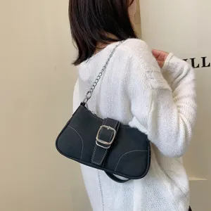 Dettaglio borsa a spalla in denim nero con tracolla a catena e fibbia argentata.