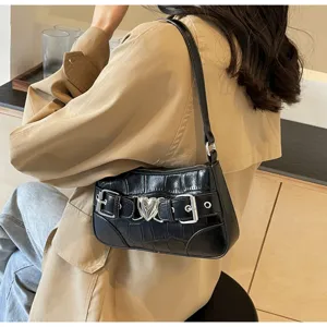 Détail de sac porté épaule noir croco, sac baguette tendance avec boucle cœur.