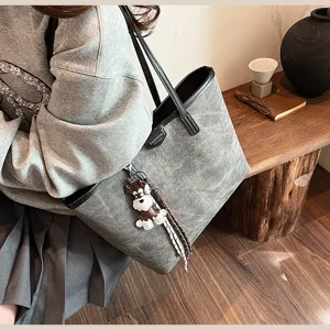 Detailansicht der grauen PU-Leder-Tote-Bag im Vintage-Stil mit stilvollem Hunde-Anhänger.