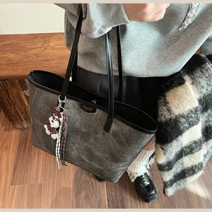 Nahaufnahme der Vintage PU Leder Tasche im Detail mit Retro Textur und charmantem Anhänger.
