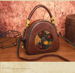 Prägnantes Detail der Ledertasche mit Blumen-Vogel-Relief und Bambus-Griffverbindung.