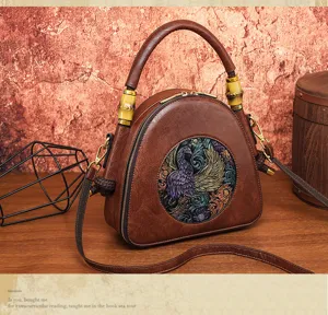 Detailansicht der vintage braunen Ledertasche mit kunstvoll geprägtem Phönix-Design.