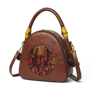 Retro geprägte Leder Umhängetasche mit ethnischem Pflaumenblüten Design und Bambus Griff.