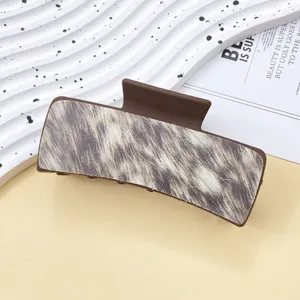 Detailed view of brown hair claw clip featuring trendy animal print texture design.