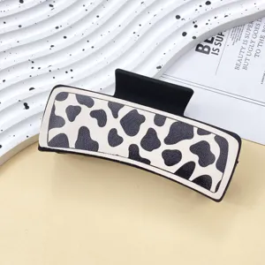 Leather hair claw clip detail, cow print fashion hair accessory, elegant grip for daily wear.