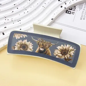Western cowboy style leather hair claw clip with highland cow and sunflower print detail.