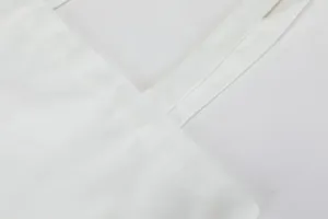 White canvas shoulder tote bag handle strap detail and fine stitching close up view