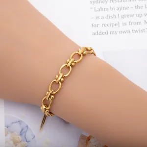 Gold titanium steel dumbbell link bracelet, stylish detail shot showing the fashion accessory design.