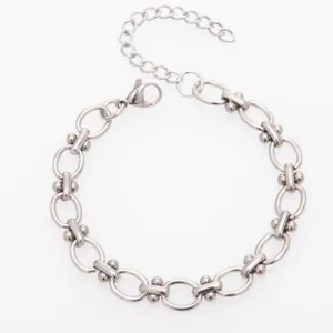 Stainless steel dumbbell link bracelet detail, silver metallic tone, modern design.