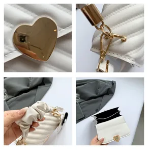 Detailed view of white quilted crossbody bag with gold heart lock and chic handle.