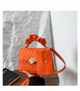 Stylish minimalist women's crossbody bag with heart clasp, ruched handle, and coin pouch.