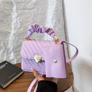 Stylish purple quilted crossbody bag with trendy scrunchie handle and heart clasp.