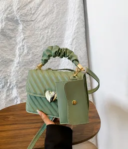 Bean green quilted crossbody shoulder bag with cute heart lock and mini coin pouch detail.